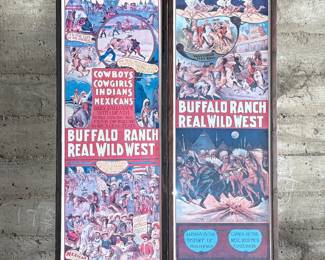 Framed posters advertising the Buffalo Ranch Real Wild West show. Printed by Riverside Print Co., Chicago, these posters feature vibrant depictions of cowboys, Native Americans, and historical scenes. The frames show some age-related wear, and the paper backing is partially torn, exposing an art gallery label from Hulmeville, Pennsylvania. One of them is protected by glass and the other is not. Each one measures in frame, 37” H x 14.5” W.