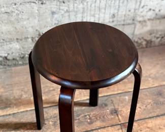 This lot features a modern wood stool in the style of the iconic Artek Stool in very good condition. This piece measures, 17.5” H x 15” W x 15” D.