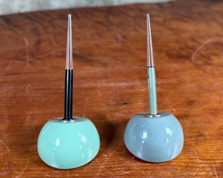 Esterbrook dip pens featuring metal nibs marked ‘Esterbrook 9556’ with black and green handles. Each pen is paired with a ceramic holder in complementing colors: green and blue-gray. Both pens are marked ‘Esterbrook Made in U.S.A.’ on the handles, denoting their authenticity. Well-preserved and functional writing tools, ideal for collectors or calligraphy enthusiasts.