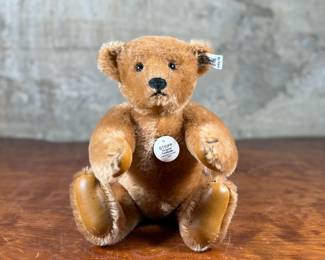 Steiff original teddy bear featuring brown mohair fur and a classic black stitched nose. Retains the trademark Steiff tag in the ear and button. In good condition with visible iconic craftsmanship.