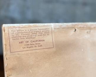 Two framed prints by Art of California, measuring 10.75” H x 10.75” W each. These are handcrafted reproductions of original paintings by Viennese artist Friedl, showcasing charming dance scenes with bright red backgrounds and decorative floral borders. Each piece is framed in light wood and features a paper backing with labeled production details.