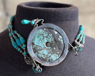 Multi-strand necklace with turquoise and silver beads featuring a large sterling silver pendant with intricate turquoise inlay and decorative elements, including hanging charms. Marked ‘925’ for sterling silver purity. This necklace measures, 19.5” and has a total approx. weight of 205.91 grams.