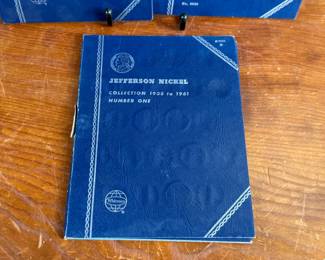 Three coin collection folders produced by Whitman Publishing Company, featuring Lincoln Cents (Collection 1909-1940, Number One; and Collection Starting 1941, Number Two) and Jefferson Nickels (Collection 1938 to 1961, Number One). The folders display various coins, including partially filled slots with different years. Condition shows general wear on the folders. Coin details and completeness vary.