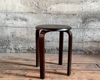 This lot features a modern wood stool in the style of the iconic Artek Stool in very good condition. This piece measures, 17.5” H x 15” W x 15” D.