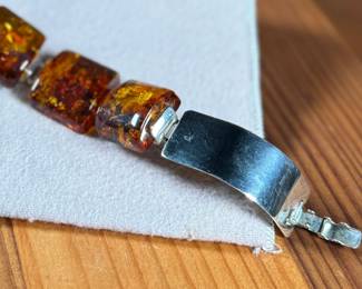 This lot features a stunning sterling silver & baltic amber bracelet that measures, 7” with a total approx. weight of 61.80 grams.