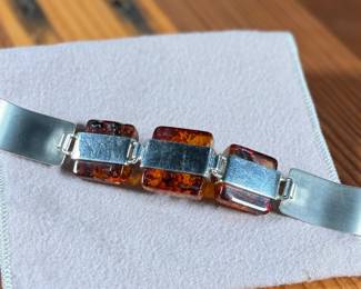 This lot features a stunning sterling silver & baltic amber bracelet that measures, 7” with a total approx. weight of 61.80 grams.