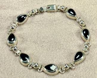 This lot features a vintage sterling silver & onyx bracelet that measures, 8.5” with a total approx. weight of 27.18 grams.
