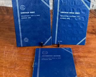 Three coin collection folders produced by Whitman Publishing Company, featuring Lincoln Cents (Collection 1909-1940, Number One; and Collection Starting 1941, Number Two) and Jefferson Nickels (Collection 1938 to 1961, Number One). The folders display various coins, including partially filled slots with different years. Condition shows general wear on the folders. Coin details and completeness vary.