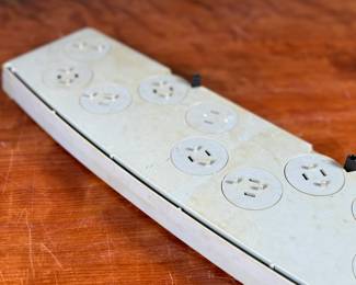 Vintage 1978 Star Wars action figure display stand by GMFGI. Marked ‘321E 001’ with a copyright of ‘G.M.F.G.I. – 1978’. Features slots marked with character names including Stormtrooper, Darth Vader, Luke Skywalker, and Princess Leia. Made of gray plastic with attached gear mechanisms on the back and visible character labels on the front. Some wear consistent with age.