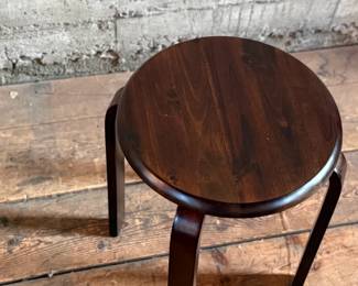 This lot features a modern wood stool in the style of the iconic Artek Stool in very good condition. This piece measures, 17.5” H x 15” W x 15” D.