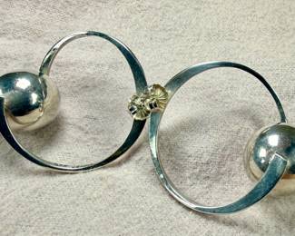 Sterling silver earrings designed in a modernist style, featuring circular hoops with a spherical accent. Marked ‘Mexico 925’, indicating its sterling silver composition. These earrings are designed with posts and butterfly back closures for secure wearing. Total approx. weight of 17.06 grams.
