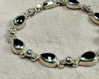This lot features a vintage sterling silver & onyx bracelet that measures, 8.5” with a total approx. weight of 27.18 grams.