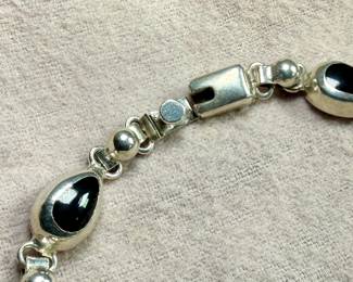 This lot features a vintage sterling silver & onyx bracelet that measures, 8.5” with a total approx. weight of 27.18 grams.
