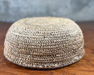 This lot features a turn of the century basket made of cedar root from the Cascades Plateau region, likely from the late 19th century or early 20th century. Measures, 3.5” H x 10” W x 10” D.