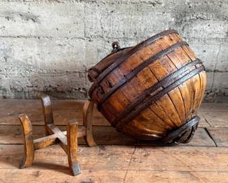 An antique Chinese wooden water bucket with stand. Features incredible patina through and well made. Measures on stand, 24” H x 18” W x 18” D.