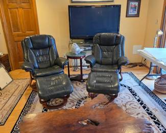 Two Stress Less leather reclining armchairs with ottomans.