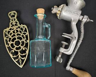 Lot #74 - Vintage Universal Metal Hand Crank Meat Grinder with Decorative Brass Trivet & Blue Glass Oil Bottle
