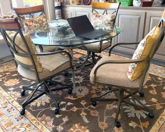 Round glass-top table with 4 rolling high-back chairs