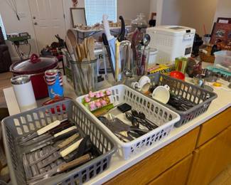 Lots of knives, silverware, serving pieces, spoons. Crock Pot
