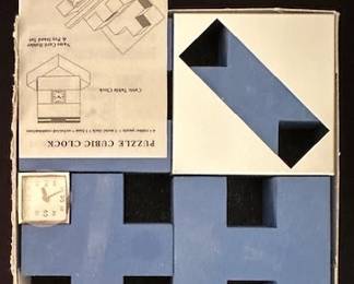 Puzzle Cubic Clock set featuring interlocking pieces, a base and metal clock face.