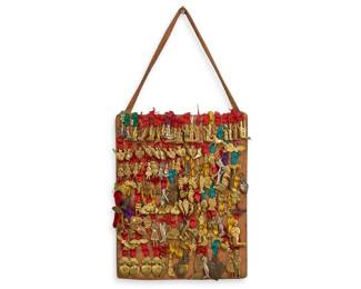 Mexican religious folk art piece featuring collection of brass and tin Mexican milagro