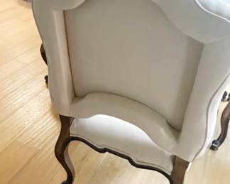 French Provincial cabriole leg chairs freshly reupholstered in cream faux leather. Host chairs feature brass nailhead trim. 