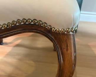 French Provincial cabriole leg chairs freshly reupholstered in cream faux leather. Host chairs feature brass nailhead trim. 