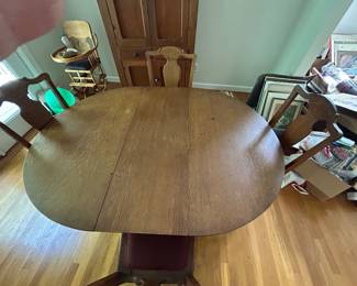 OAK CLAW FOOT TABLE AND CHAIRS WITH AN EXTRA LEAF.