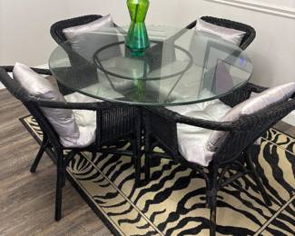 Dinning set: 4 black wicker chairs and Round glass table on metal base. $250.00 set. Tbl: 48” diameter 30” t. Chr: 23”w 17”d 30”t