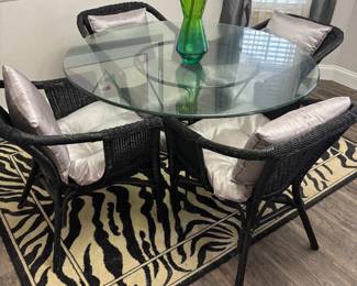 Dinning set: 4 black wicker chairs and Round glass table on metal base. $250.00 set. Tbl: 48” diameter 30” t. Chr: 23”w 17”d 30”t