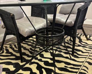 Dinning set: 4 black wicker chairs and Round glass table on metal base. $250.00 set. Tbl: 48” diameter 30” t. Chr: 23”w 17”d 30”t