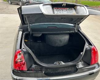 Good size trunk with spare tire and jack assembly. Note back left rear tail light cover is broken.