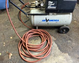 Air America 1 hp 8 gallon air compresser with hose and inflator gauge.