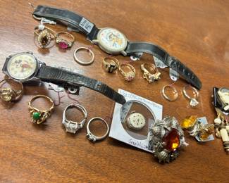 An assortment of 10 and 14 karat gold rings, Sterling rings, Richard Nixon watch, Mickey Mouse watch and a few miscellaneous pieces of jewelry.