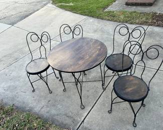 A set of ice cream chairs with the wrought iron spectacles patter with a matching parlor ice cream table.