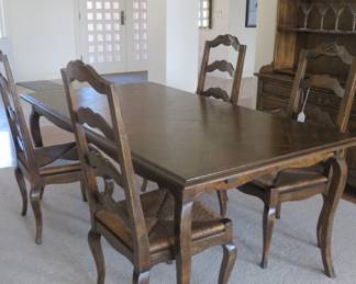 Guy Chaddock French country dining table with three leaves. Six matching chairs (two armchairs) with rush seats and ladder backs.