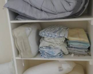 Alarge amount of bedding throughout the house including pillows, sheets and comforters.