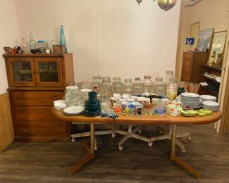 This dining table has another leaf to make it extra long, and is covered in glassware