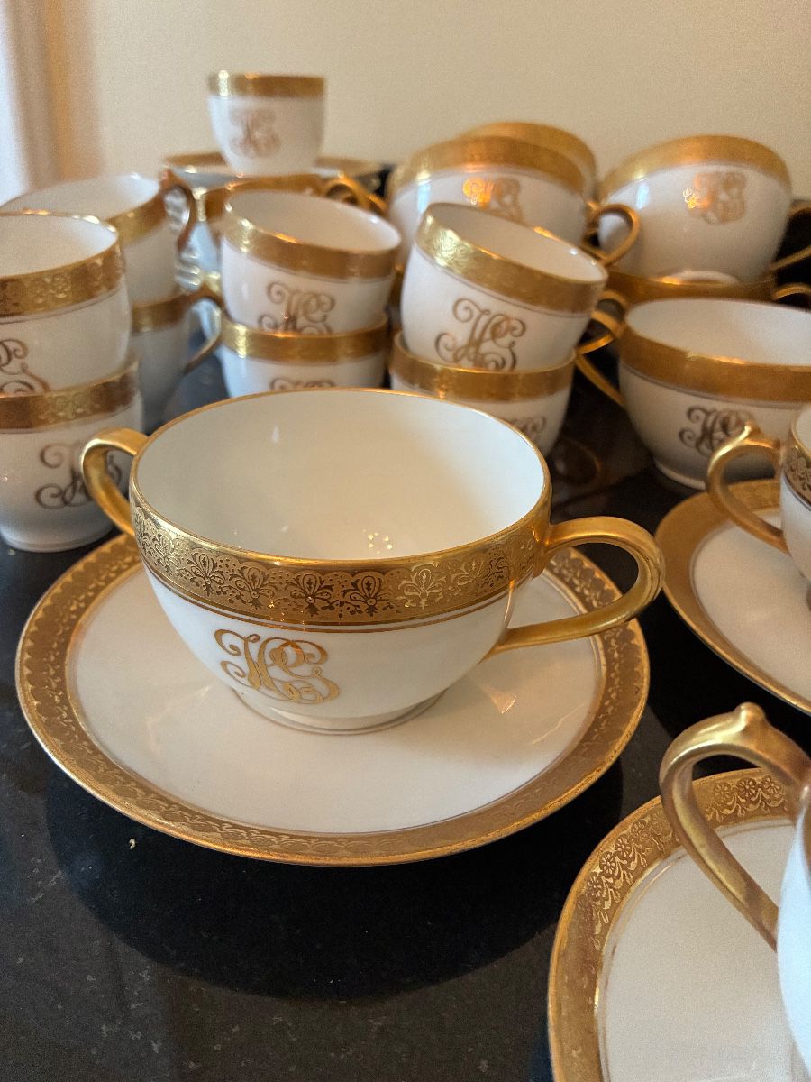 Gold-rimmed Limoges tea cups, espresso cups, and bouillon cups with saucers