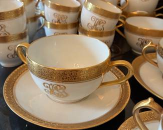 Gold-rimmed Limoges tea cups, espresso cups, and bouillon cups with saucers