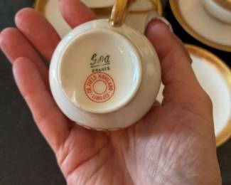 Gold-rimmed Limoges tea cups, espresso cups, and bouillon cups with saucers