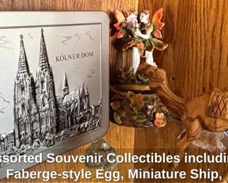 Assorted Souvenir Collectibles including Fabergestyle Egg, Miniature Ship, Egyptian Mug, Matryoshka Doll, Cologne Cathedral Tin, and Camel Figurine second image