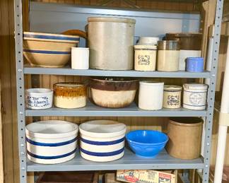 Entering the basement, shelves filled with antique crocks and wood boxes with advertising.