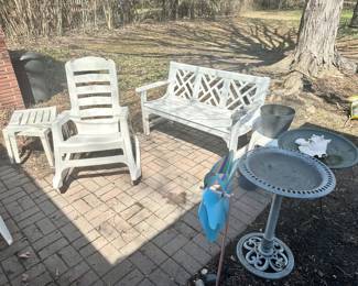 Outdoor furniture and decor including a heavy metal bench.