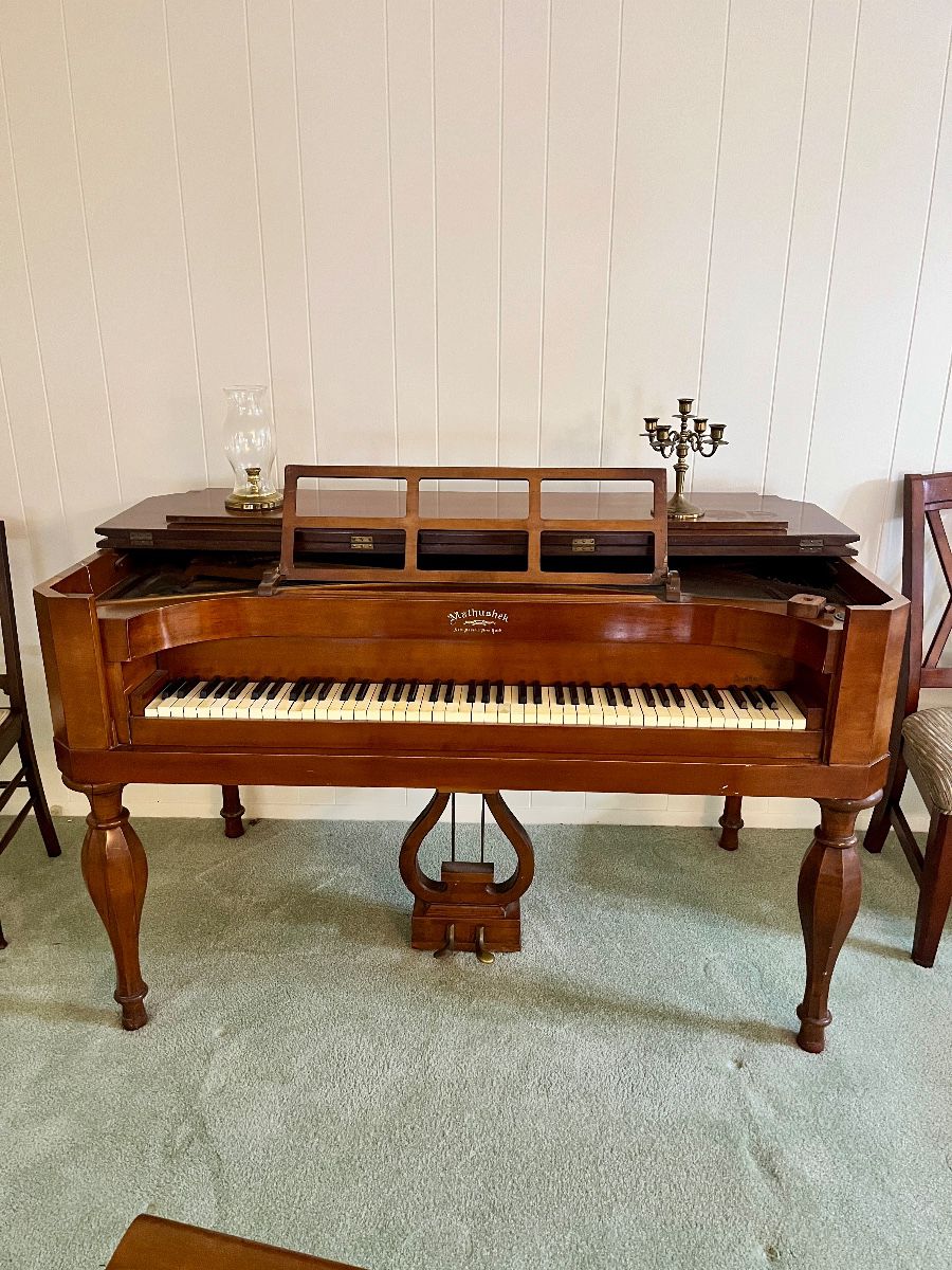 Very Rare 20th Century “Early American” Style Mathushek Spinet Grand Piano In Brown Mahogany Wood. In the 1930s era, the Mathushek firm went against the norm and introduced a line of tiny square grand pianos called the Spinet Grand. These "contemporary" instruments were based on the same general design of Mathushek 19th Century square grand pianos, but were redesigned in style and appearance so that they would fit well with décor.