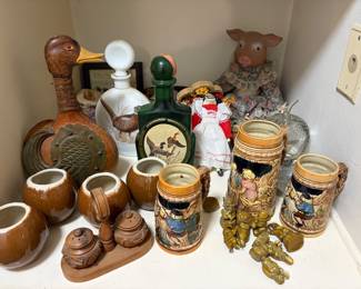 Jim Beam whiskey decanters featuring wildlife artwork by James Lockhart. vintage Italian duck-shaped decanter made of glass wrapped in hand-tooled leather. vintage German-style beer stein. collectible porcelain-head pig doll