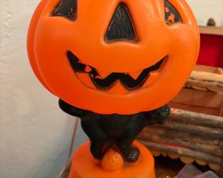vintage 1960s blow mold decoration features a large Jack-O'-Lantern head resting on a black cat base
