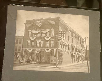 Lot 83: Cabinet Photo Holiday decorated small city building and general store about 1900 American flags