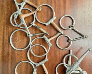 Collection of metal snaffle bits (for horse riding).