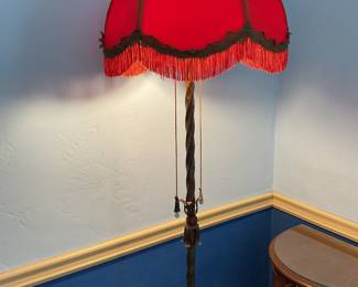 Red fabric lampshade with fringe on dual pole, antique floor lamp